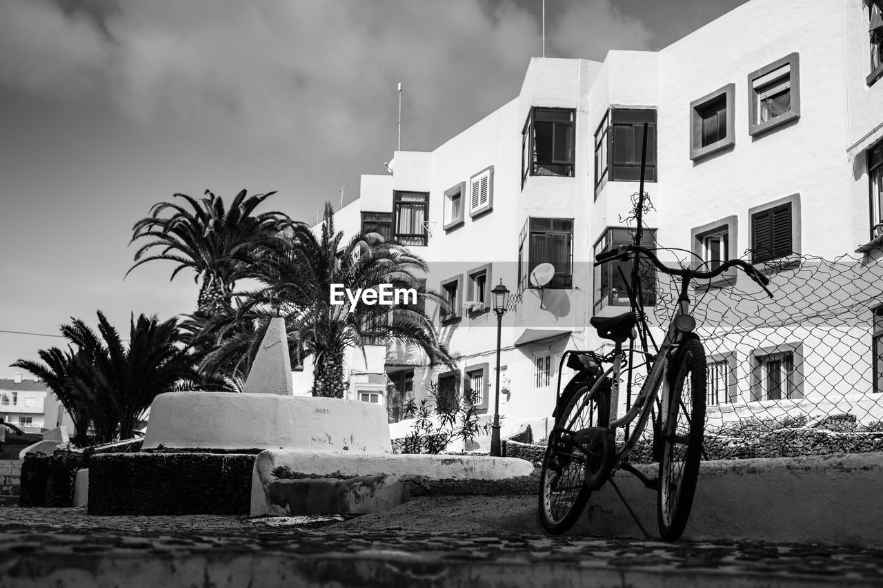 Low angle view of bicycle and buildings against sky