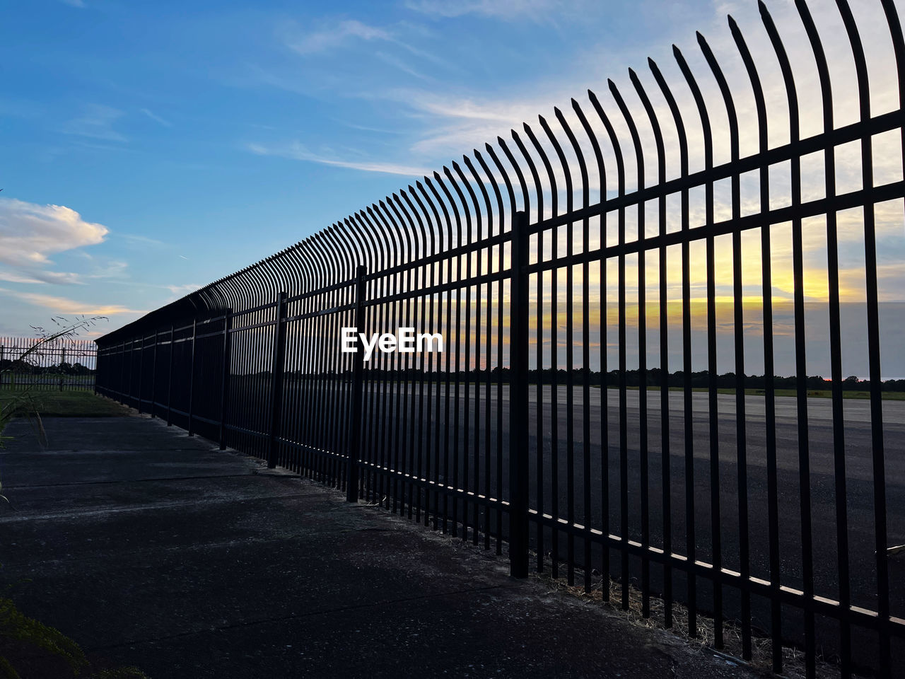 sky, architecture, cloud, nature, no people, built structure, transportation, line, fence, outdoors, day, security, urban area, city, metal, protection