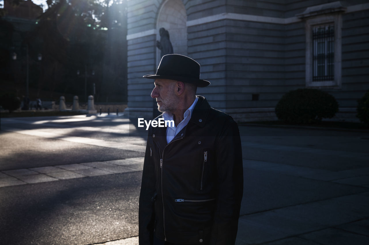 Adult man in hat and leather jacket on square. madrid, spain
