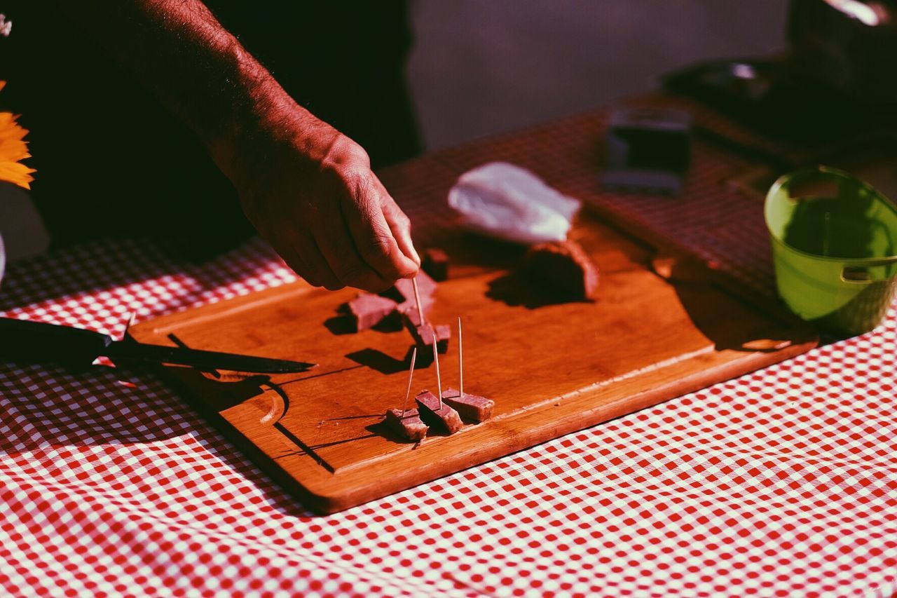Cropped image of man holding food on wooden tray at market stall