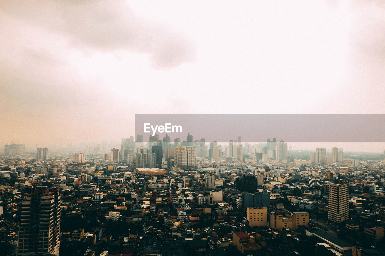 HIGH ANGLE VIEW OF BUILDINGS IN CITY AGAINST SKY