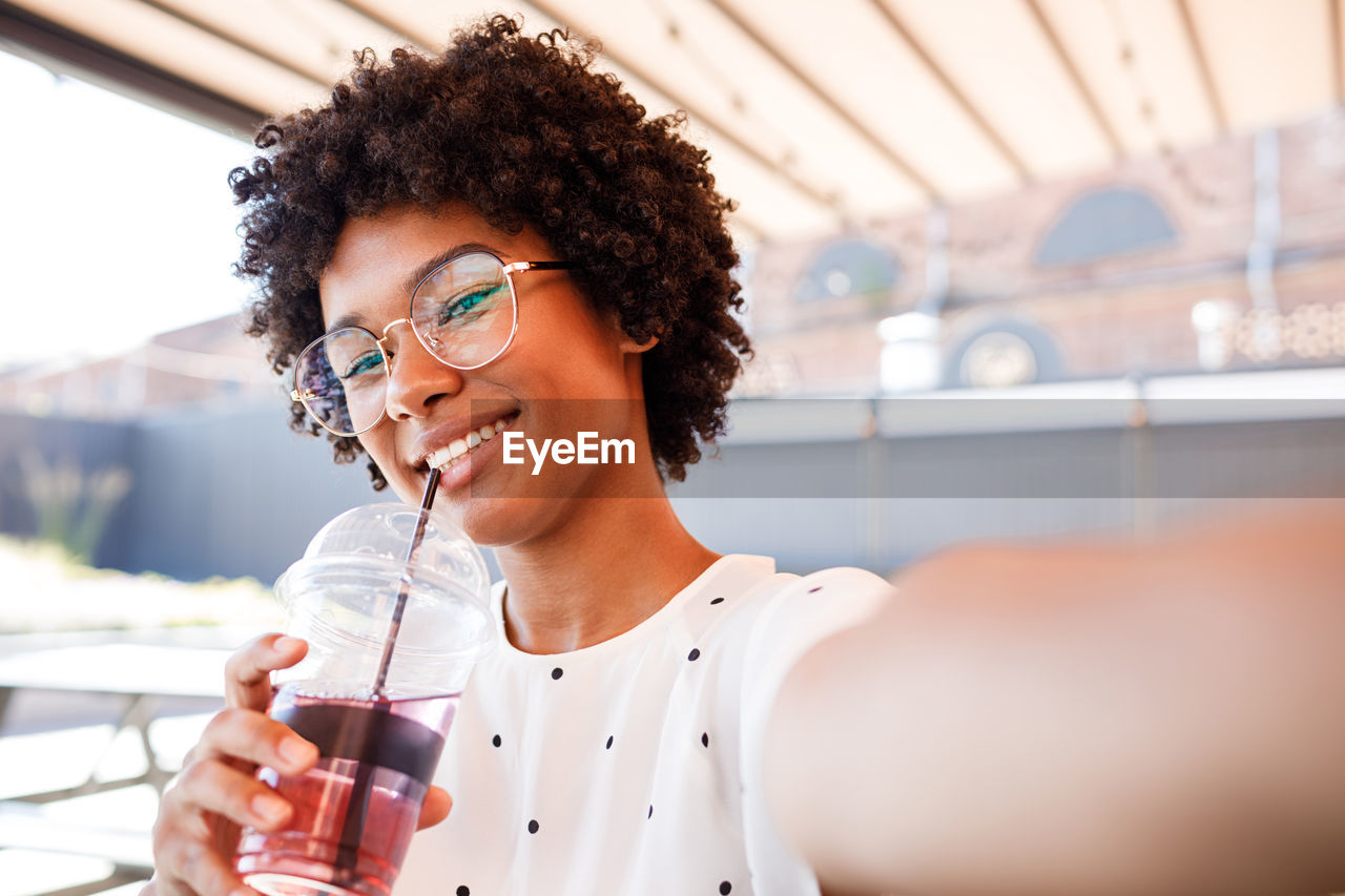 Portrait of smiling woman drinking in cafe