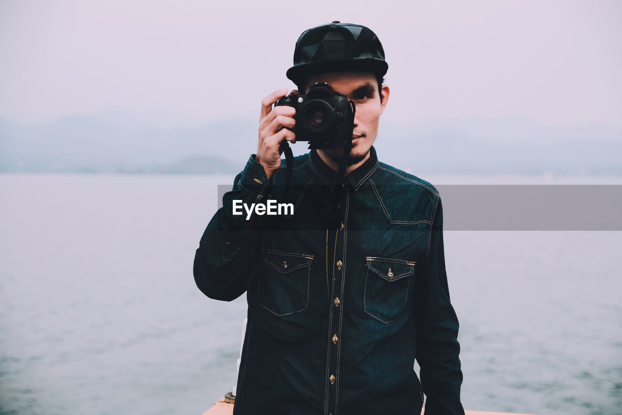 Man photographing from camera by sea