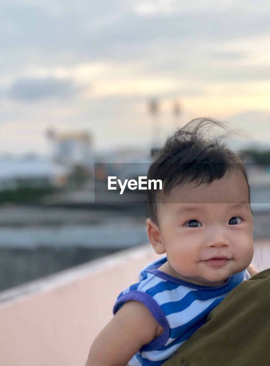 Portrait of cute baby boy against sky