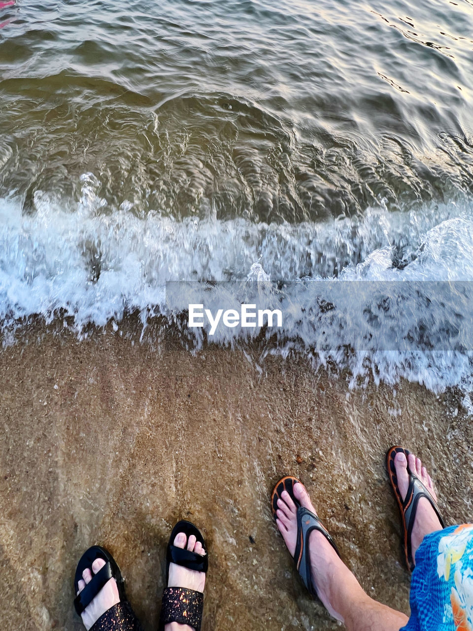 water, beach, low section, human leg, shoe, land, sea, sand, lifestyles, personal perspective, leisure activity, high angle view, day, nature, water sports, standing, surfing, men, sandal, sports, wave, shore, two people, outdoors, ocean, human foot, adult, women, coast, motion, togetherness, flip-flops, vacation, trip, beauty in nature, limb, holiday, wet