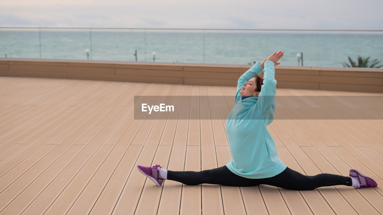 full length of woman exercising on floor