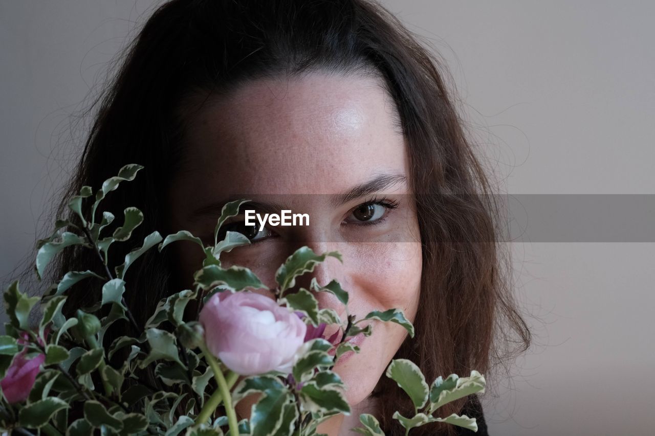 Close-up portrait of woman with pink flower