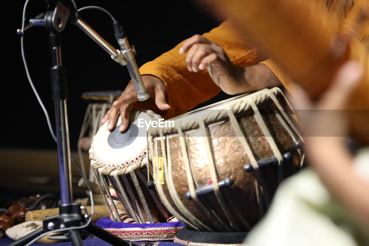 music, drums, musical instrument, arts culture and entertainment, percussion, musician, drummer, performance, adult, musical equipment, drum, one person, skill, indoors, hand, occupation, concert, selective focus, entertainment, membranophone, men, guitar, event, drum - percussion instrument