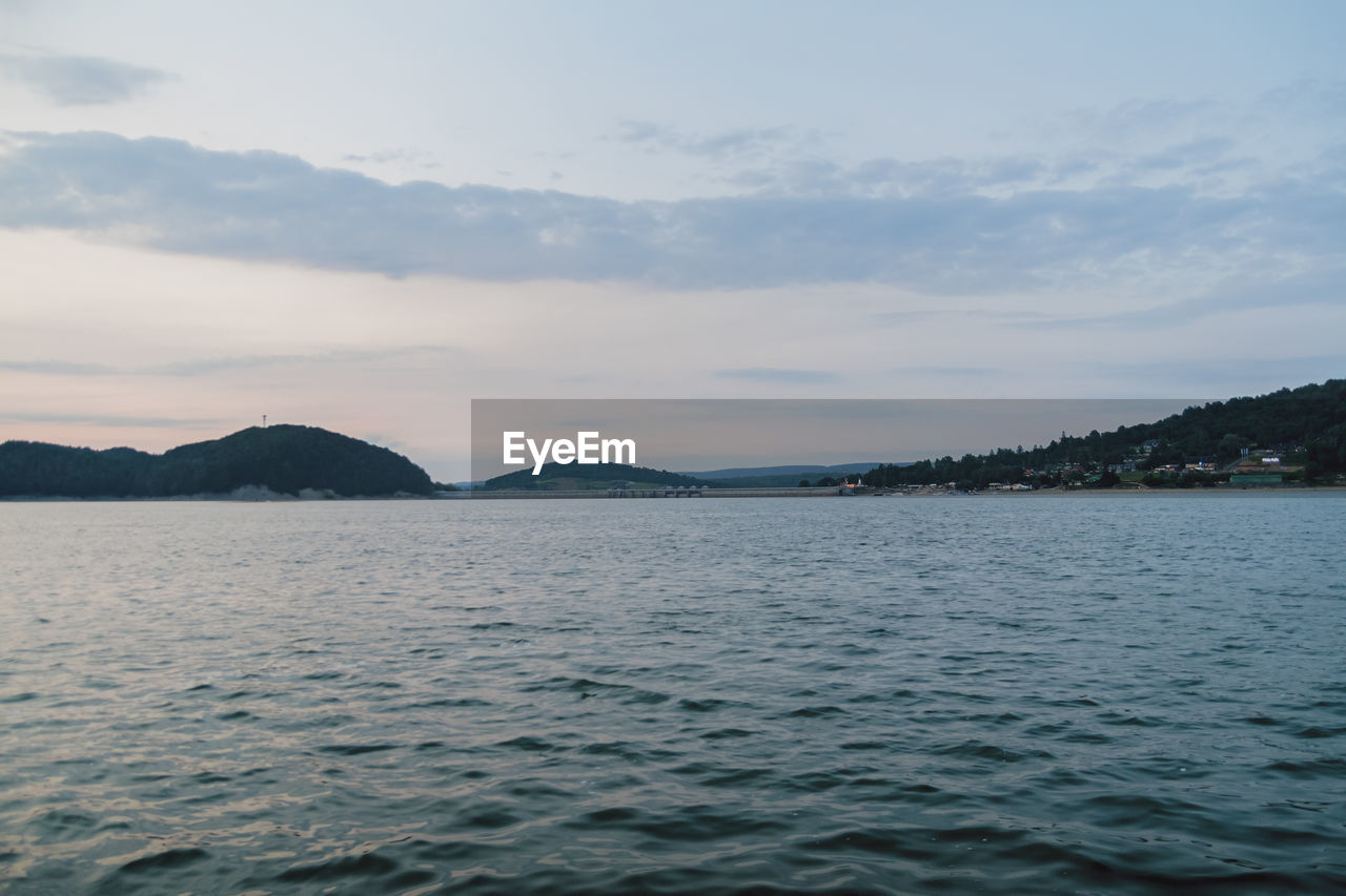 SCENIC VIEW OF SEA BY MOUNTAINS AGAINST SKY