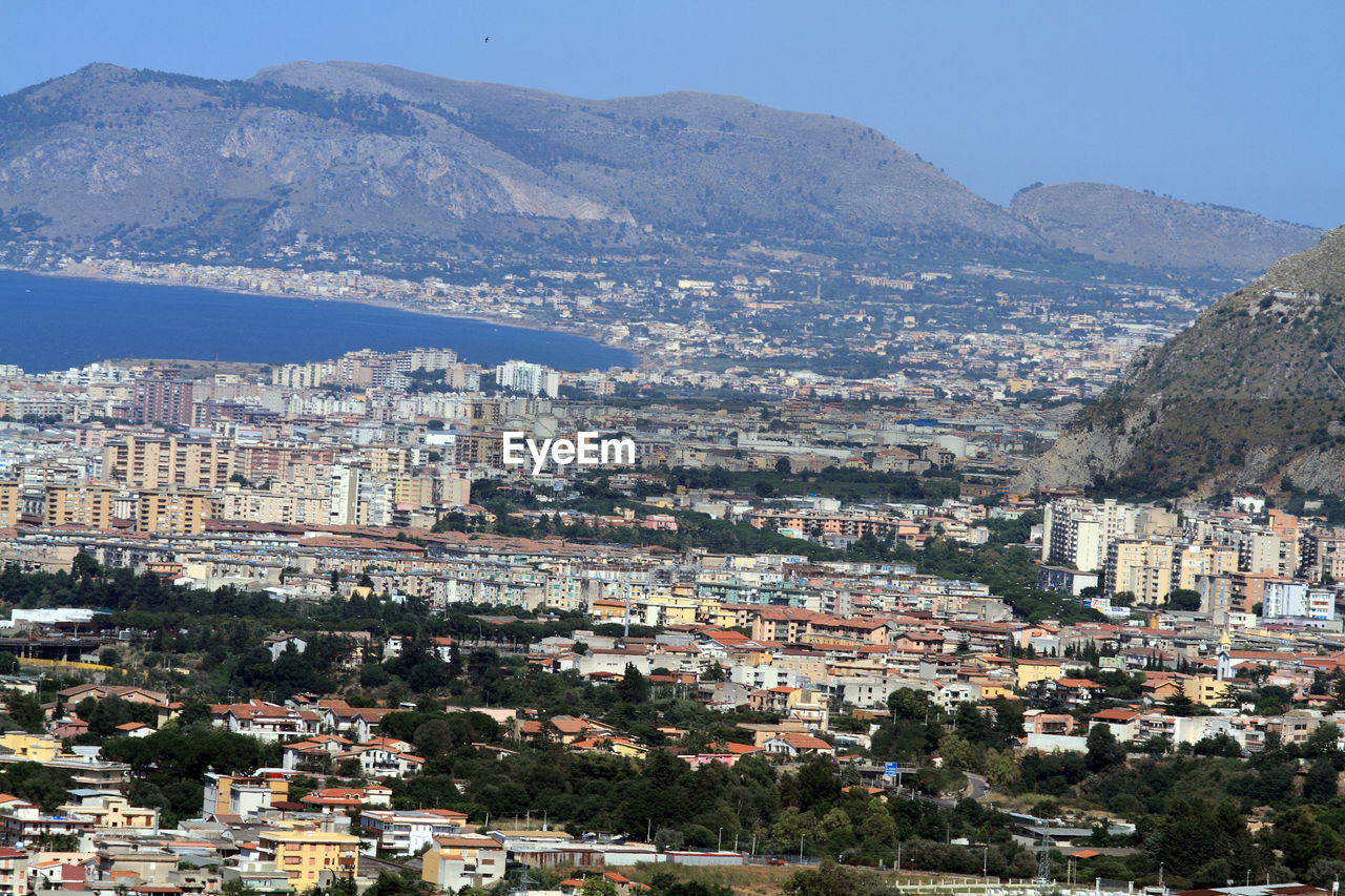 HIGH ANGLE VIEW OF TOWNSCAPE AGAINST MOUNTAINS