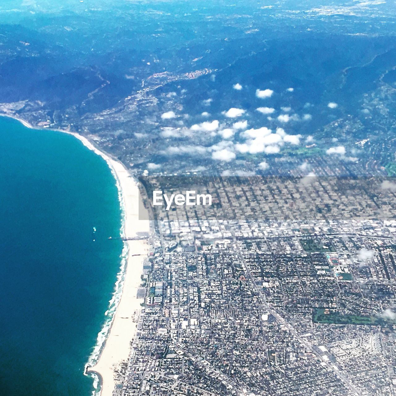 AERIAL VIEW OF CITYSCAPE WITH SEA IN BACKGROUND