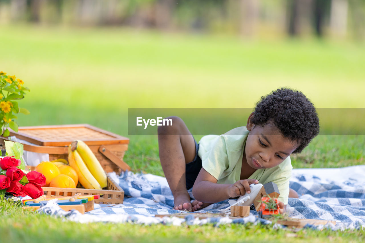 side view of boy playing with vegetables at park