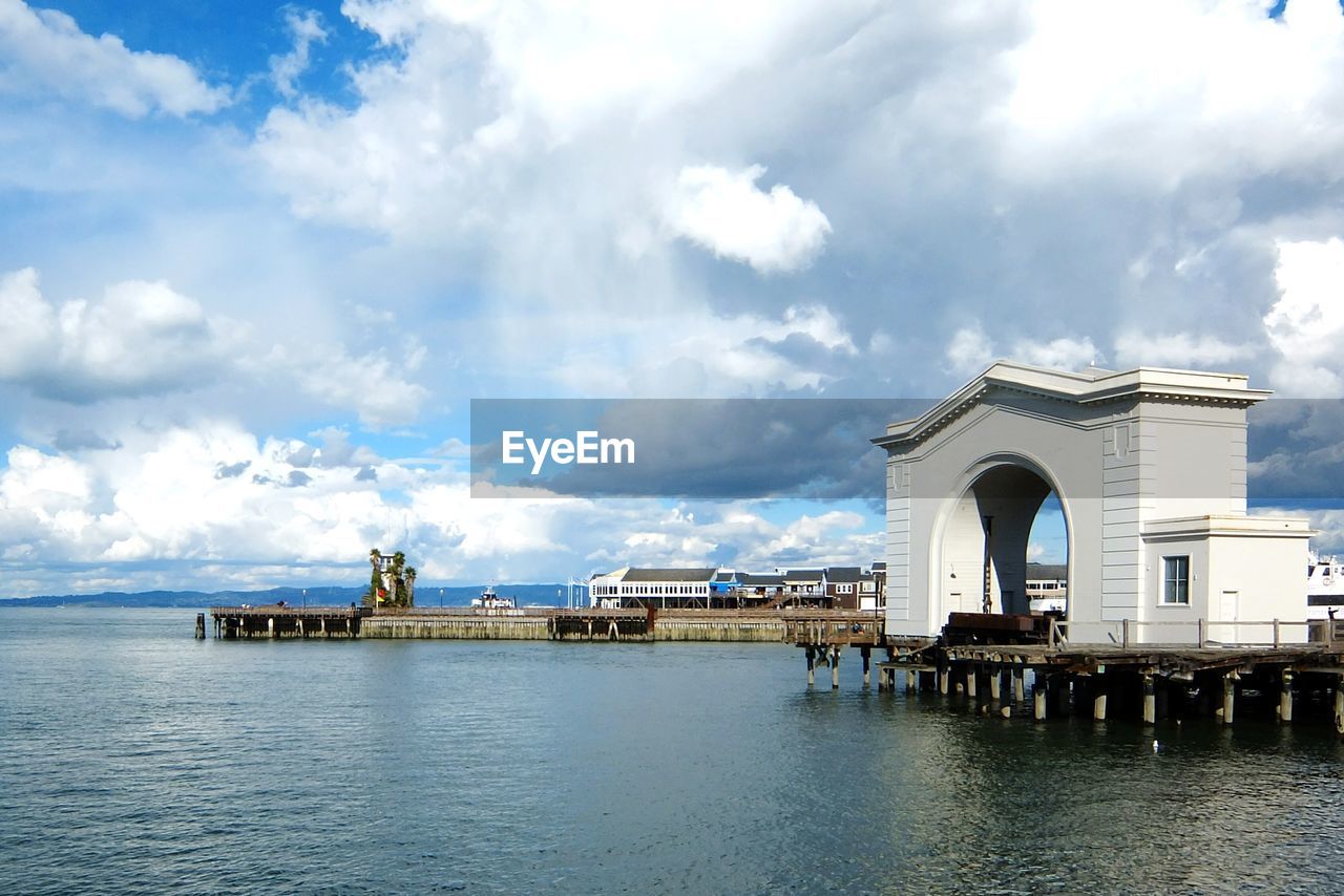 Arch structure on pier over sea against sky