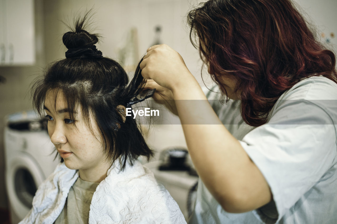 Teens dye their hair white, apply the dye to her hair at home