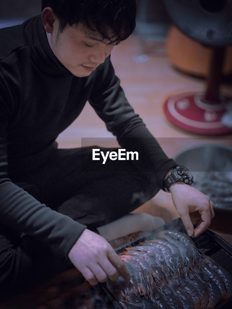 HIGH ANGLE VIEW OF MAN PREPARING FOOD ON TABLE