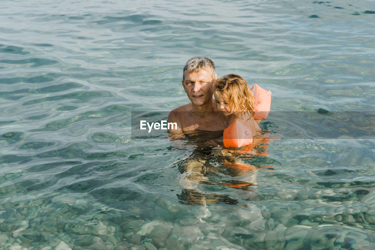 PORTRAIT OF SHIRTLESS MAN IN WATER