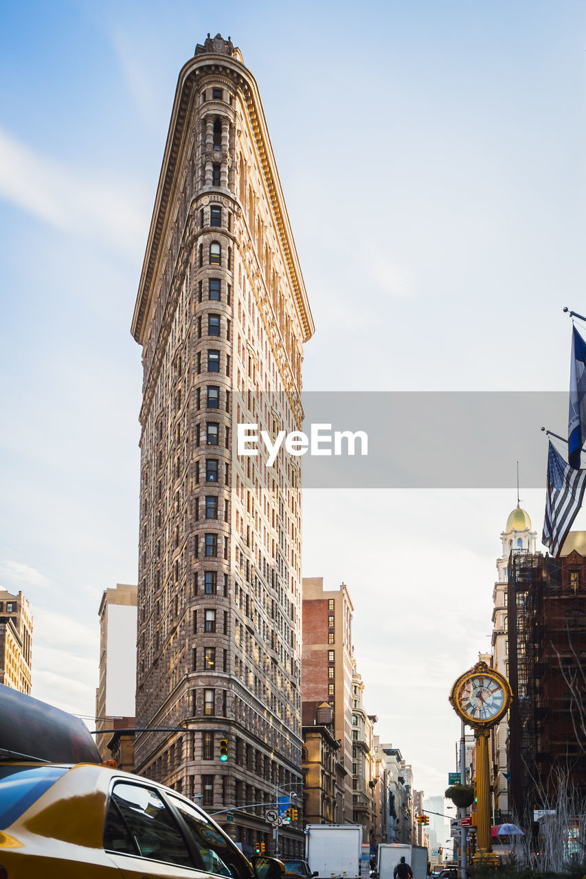 New york street activity during the day by beautiful clear blue sky at the flatiron building, nyc