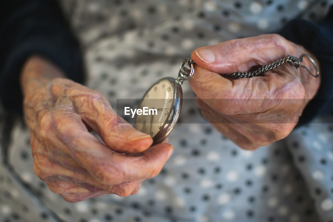 Close-up of senior woman holding pocket watch