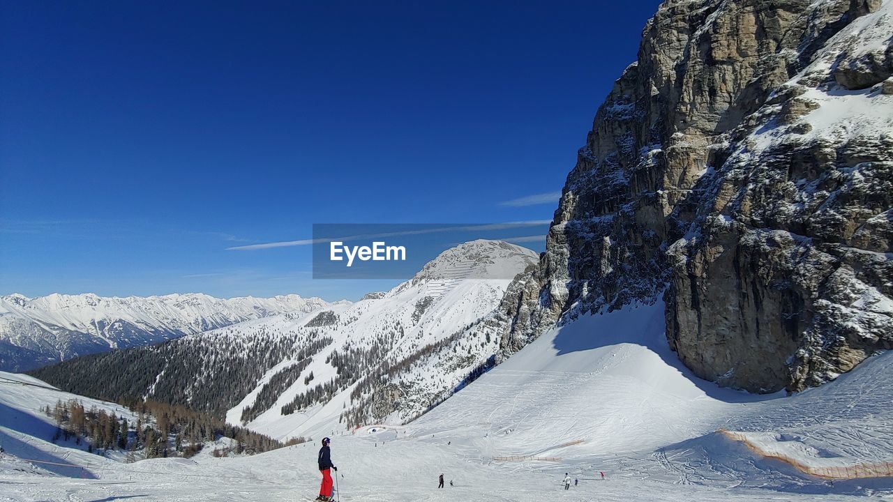 Scenic view of snowcapped mountains against clear blue sky