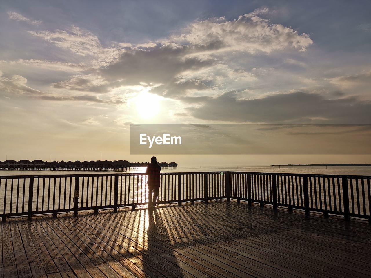 SILHOUETTE MAN STANDING ON PIER OVER SEA AGAINST SKY