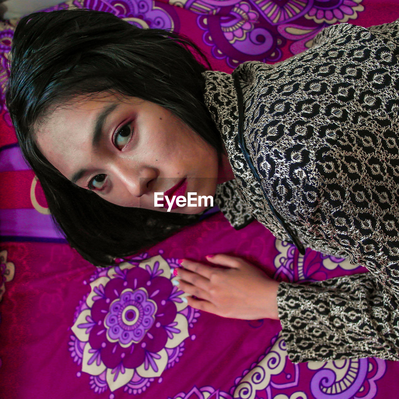 Portrait of beautiful woman lying on carpet