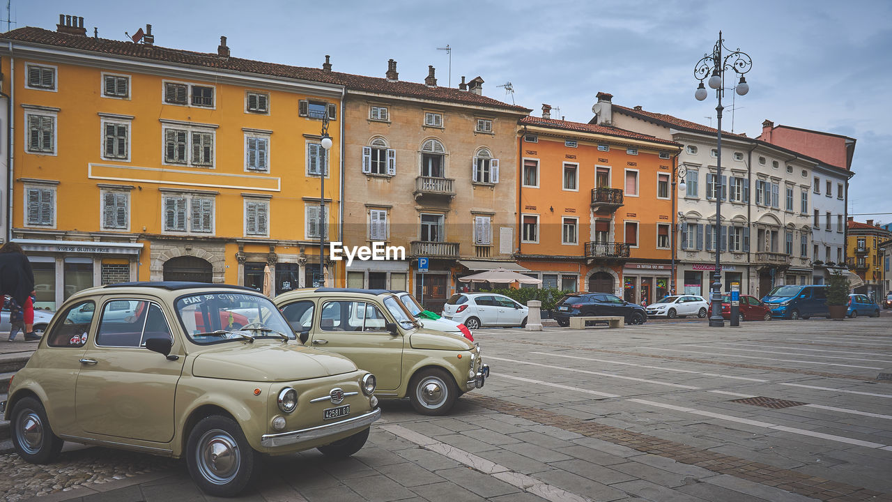 CARS ON STREET AGAINST BUILDINGS