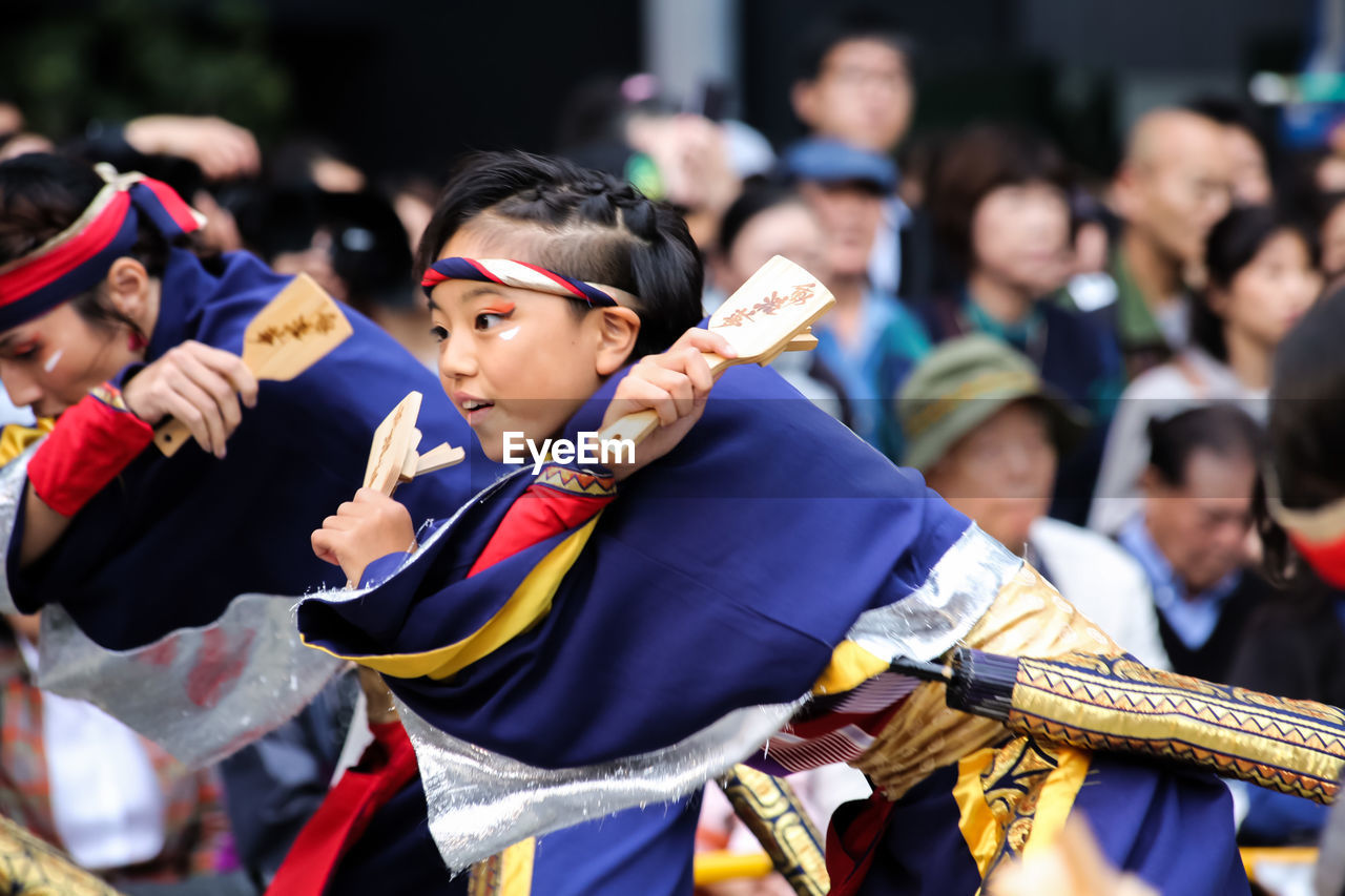 CLOSE-UP OF BOYS STANDING ON PEOPLE