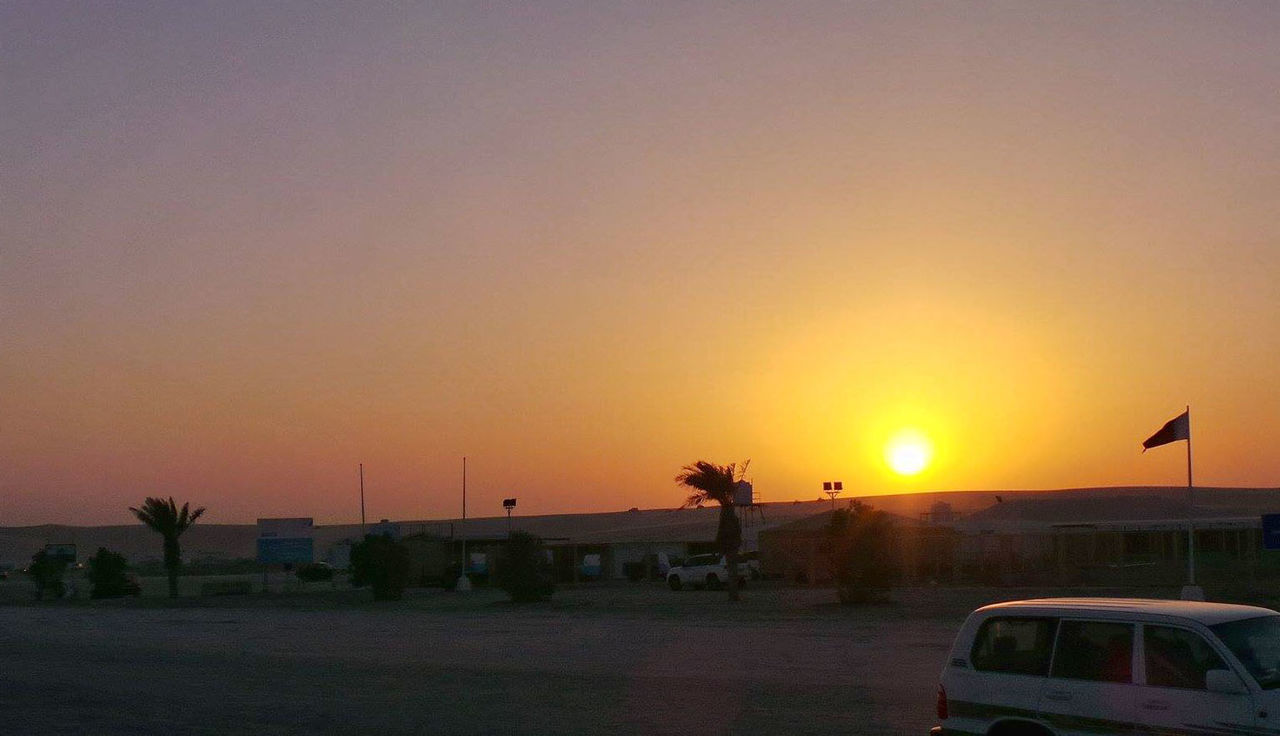 Vehicle on road against sky during sunset