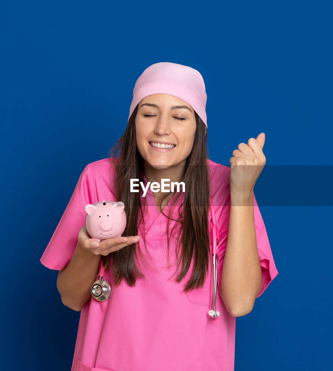 PORTRAIT OF A SMILING YOUNG WOMAN OVER PINK BACKGROUND