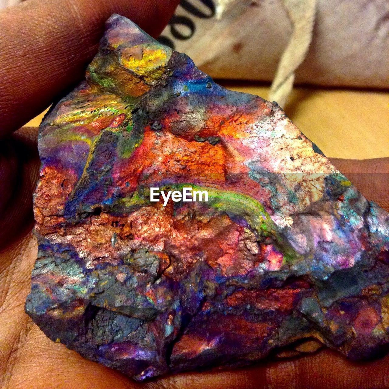 Cropped image of hand holding colorful rock