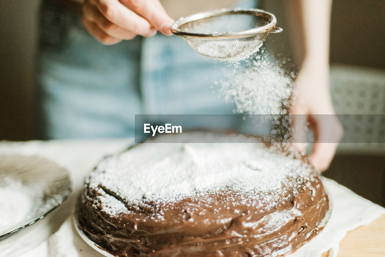 Woman cooking a chocolate cake in kitchen at home.