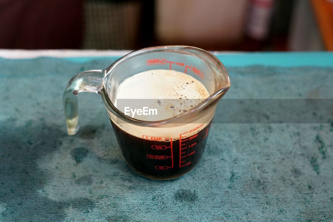 Preparing a coffee completed from the machine to pour in a ice coffee glass.