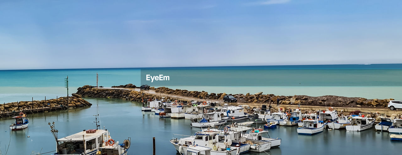 water, sea, nautical vessel, sky, transportation, horizon over water, vacation, horizon, nature, land, marina, coast, mode of transportation, scenics - nature, beach, moored, ship, vehicle, harbor, beauty in nature, travel destinations, bay, travel, no people, dock, day, ocean, port, tranquility, architecture, blue, body of water, shore, outdoors, tranquil scene, idyllic, boat, tourism, high angle view, cloud, pier, yacht, seascape, trip, holiday, building exterior, waterfront