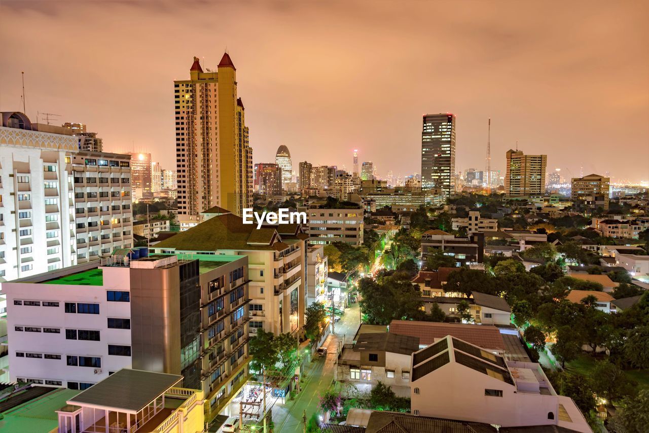 Illuminated cityscape against sky at dusk