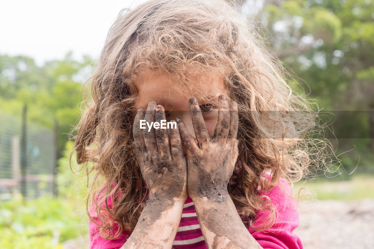 Close-up portrait of girl with dirty hands