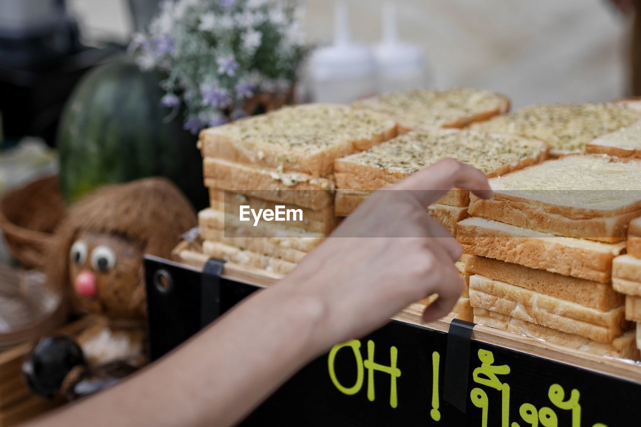 CLOSE-UP OF PERSON HAND HOLDING BREAD