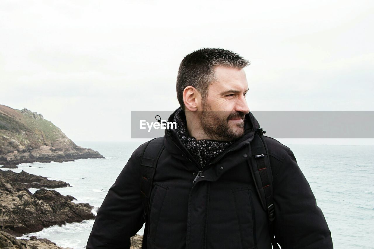 Man looking away against sea