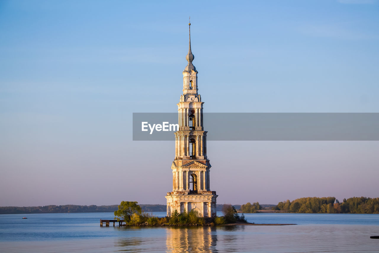 Beautiful christian church with golden domes among green trees.