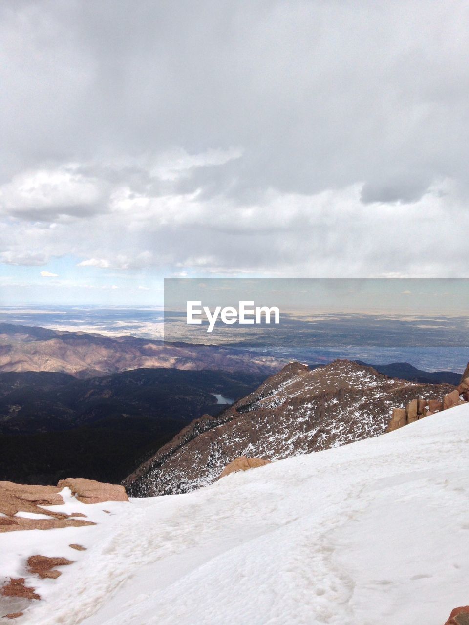 AERIAL VIEW OF SNOWCAPPED MOUNTAINS AGAINST SKY