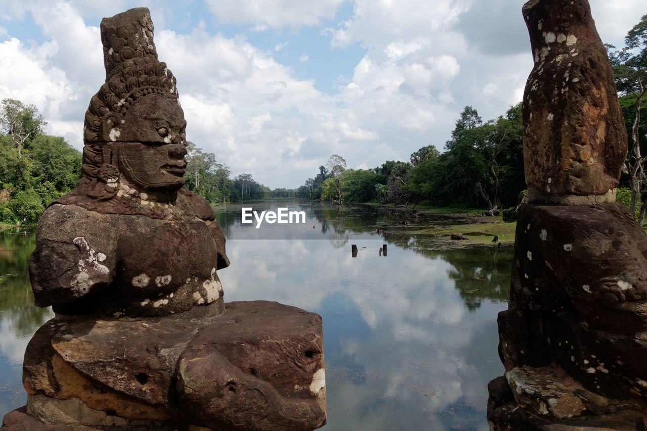 Asian statue against sky with water