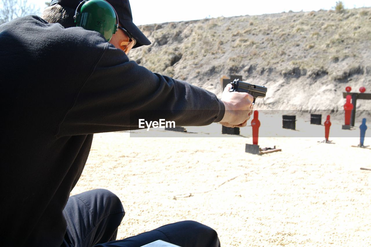 Man practicing shooting target on field