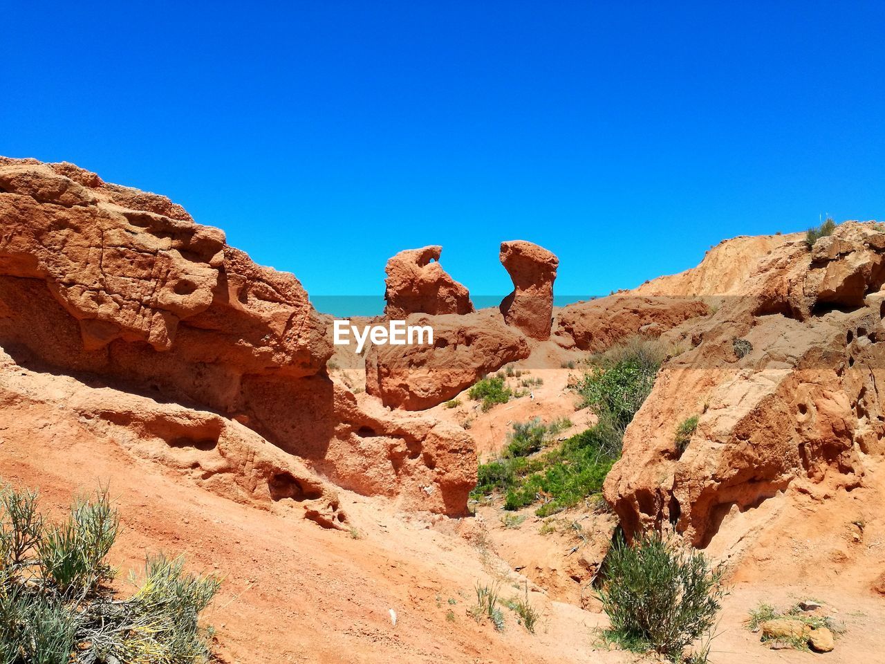 Rock formations in desert against clear blue sky