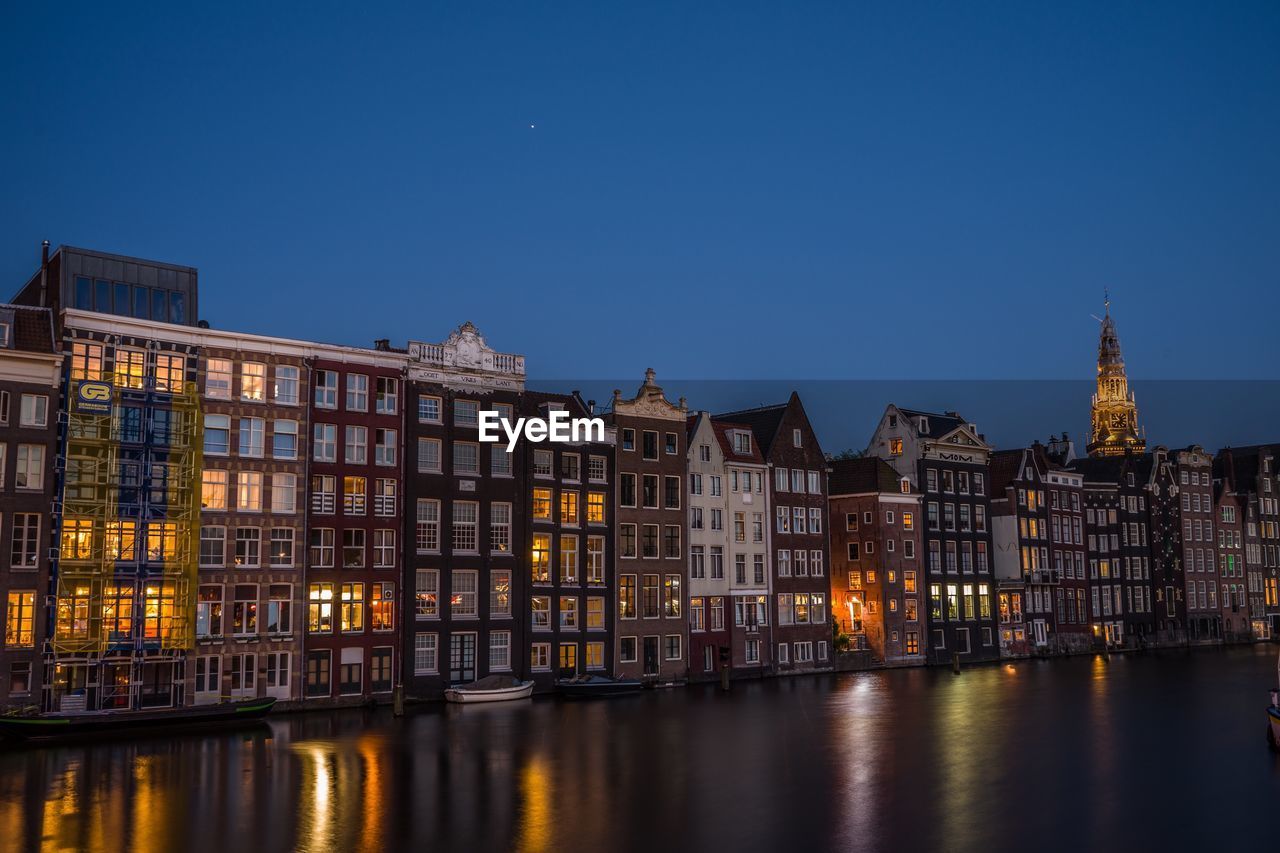 Illuminated buildings against sky at dusk