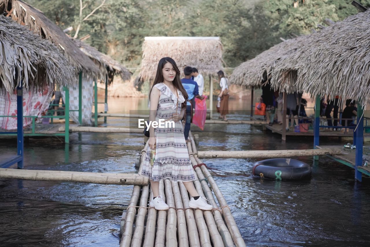 Full length of woman standing on walkway over lake