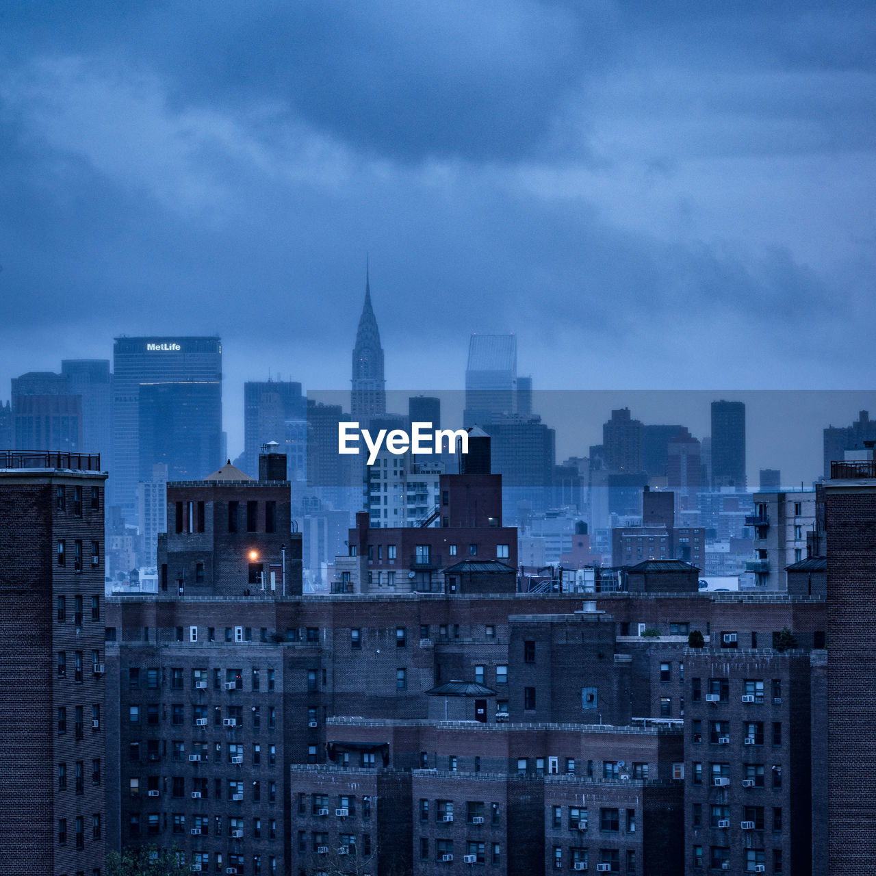 Chrysler building against cloudy sky in city at dusk