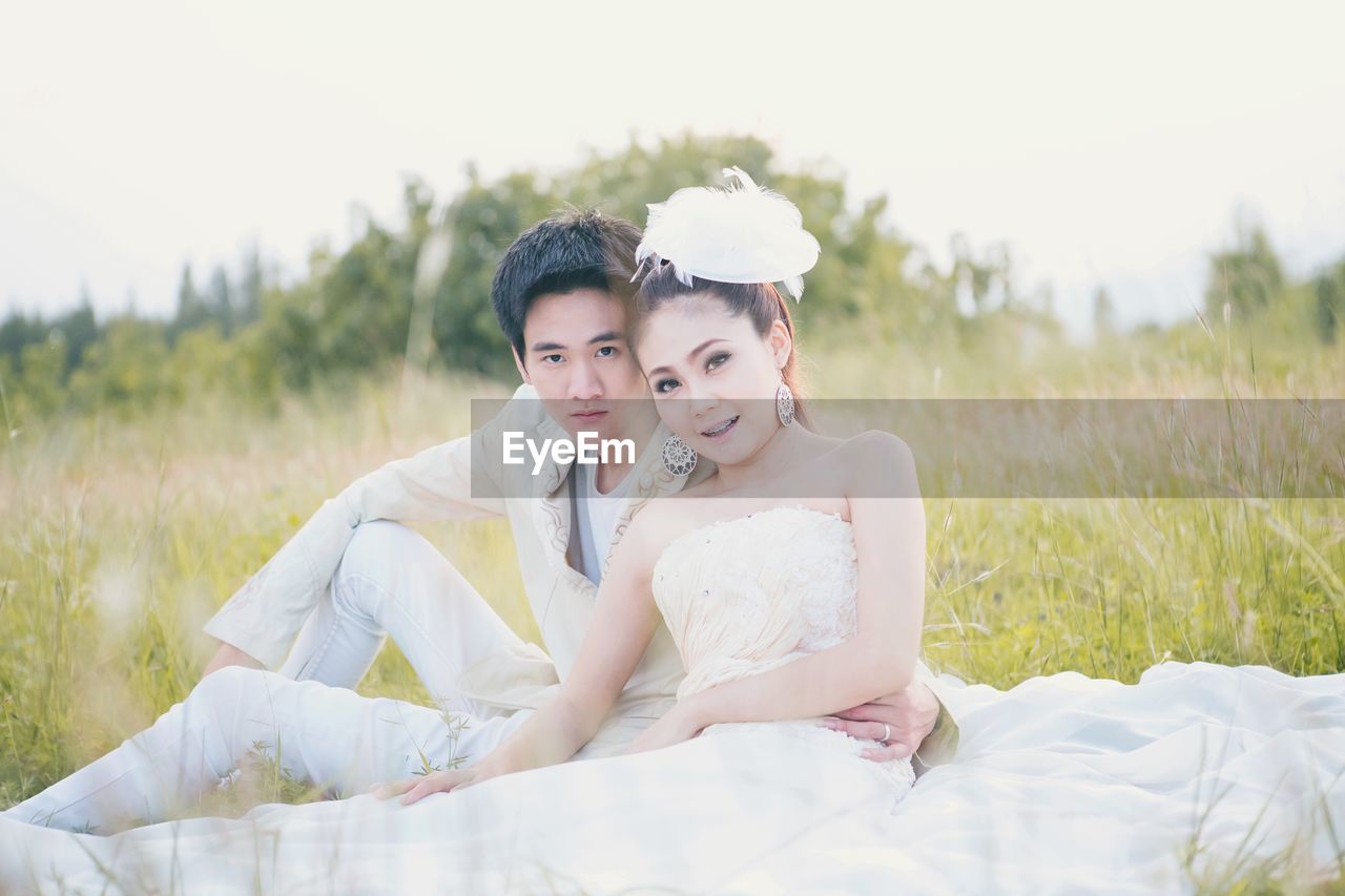 Portrait of young couple sitting on grass