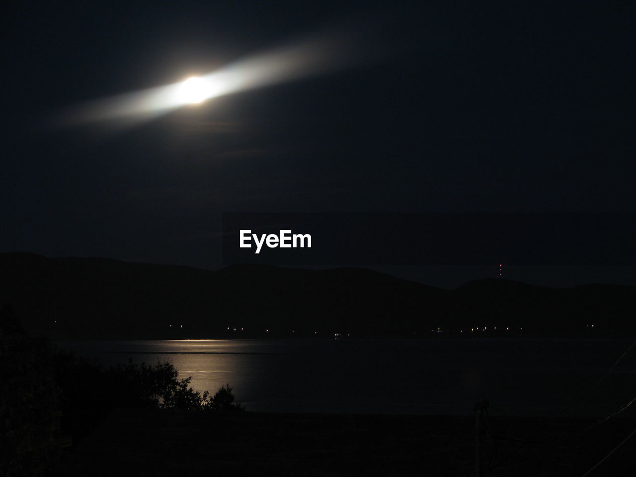 Scenic view of lake against sky at night