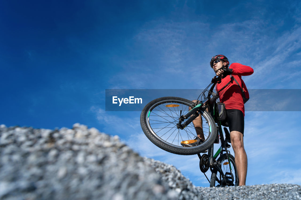 Low angle view of man riding bicycle on mountain