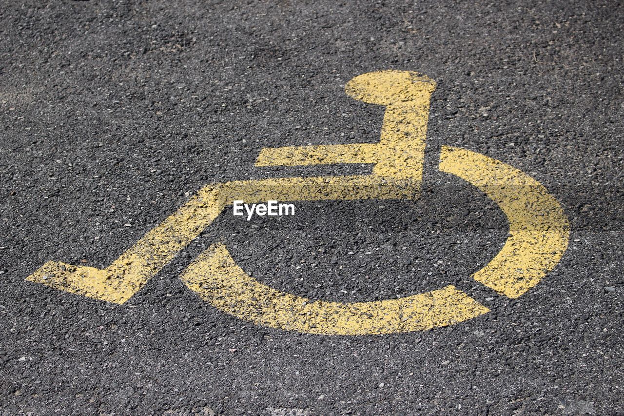 High angle view of yellow disabled sign on street