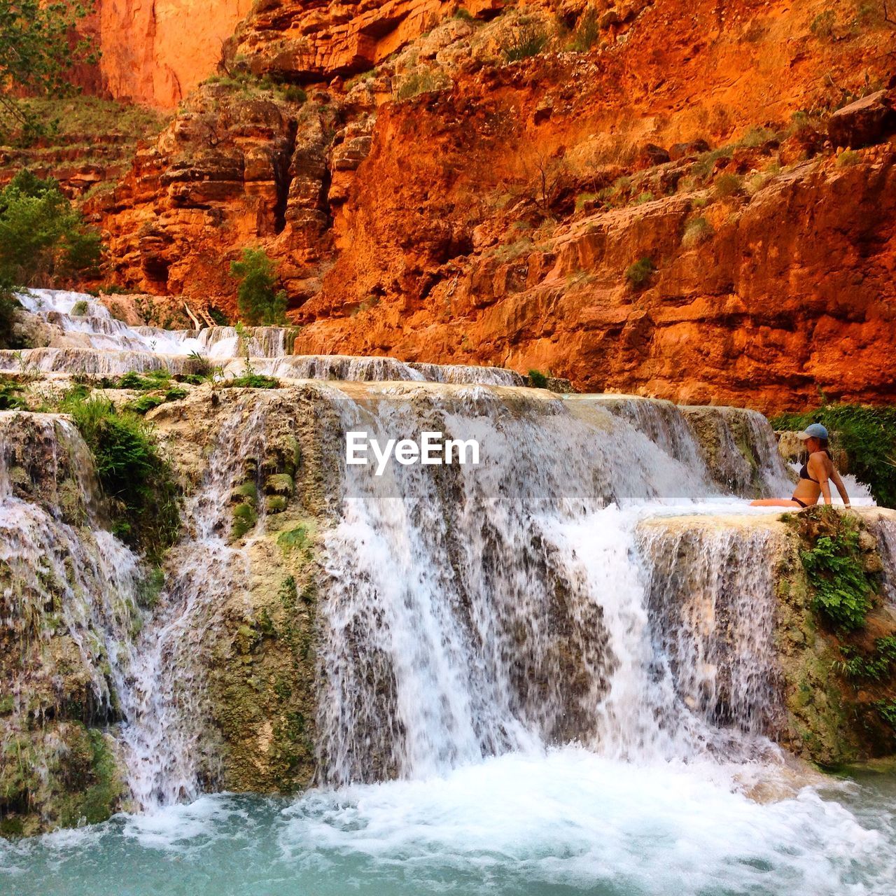 SCENIC VIEW OF WATERFALL AGAINST ROCKS